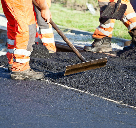 Workers laying asphalt