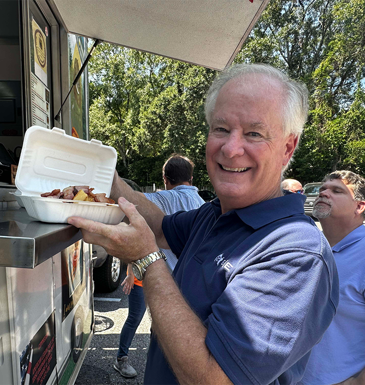 Smiling with food from a food truck.